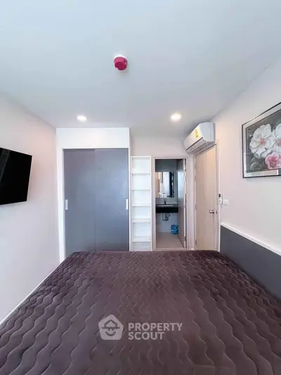 Modern bedroom with stylish decor and ensuite bathroom in a contemporary apartment.