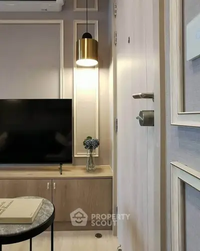 Modern living room with stylish decor and wall-mounted TV in a cozy apartment.