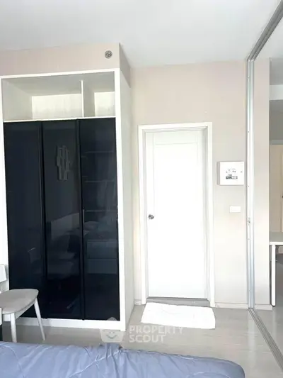 Modern bedroom with sleek black wardrobe and minimalist decor