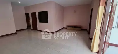 Spacious empty room with tiled flooring and natural light, ideal for customization.