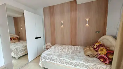 Cozy bedroom with stylish wood paneling and mirrored wardrobe, perfect for modern living.