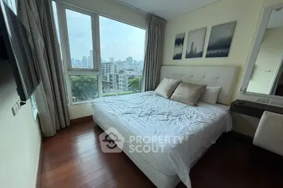 Cozy bedroom with city view, featuring a comfortable bed and modern decor, perfect for urban living.