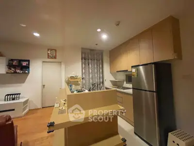 Cozy kitchen with modern appliances and wooden cabinetry in a stylish apartment.