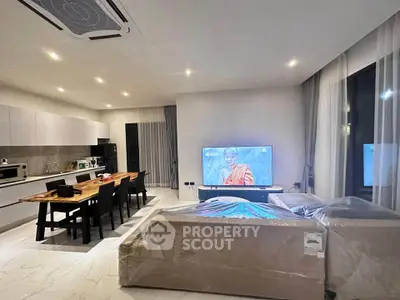 Modern open-plan living room and kitchen with sleek design and cozy ambiance.