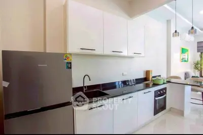 Modern kitchen with sleek cabinetry and stainless steel appliances in a stylish apartment.