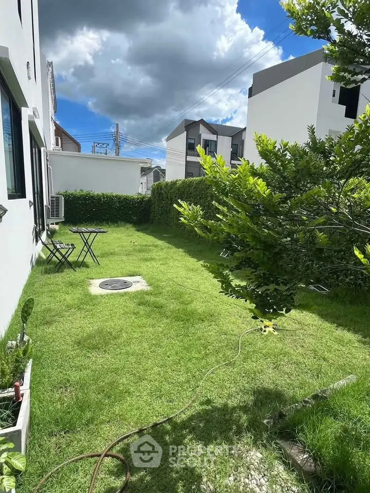 Charming garden view with lush greenery and outdoor seating in modern residential area.