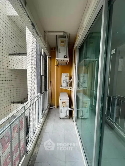 Spacious balcony with air conditioning units in modern apartment building.