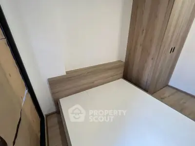 Modern minimalist bedroom with wooden wardrobe and bed frame, showcasing sleek design.