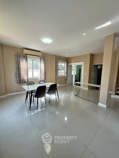Spacious dining area with modern table and chairs, large windows, and glossy tiled flooring.