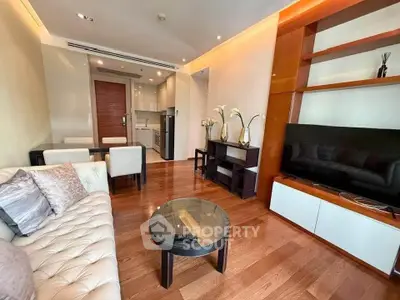 Luxurious living room with modern decor, plush seating, and sleek entertainment center in upscale apartment.