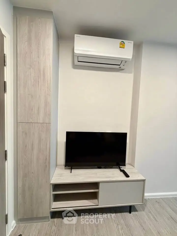 Modern living room with sleek TV unit and air conditioning in a stylish apartment.