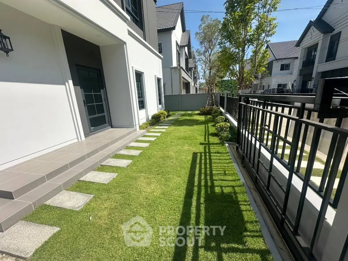 Charming modern townhouse with lush green garden and stylish exterior design, perfect for family living.