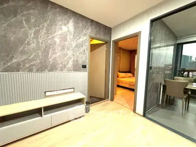 Modern apartment interior with stylish living area and dining space, featuring elegant design and natural lighting.