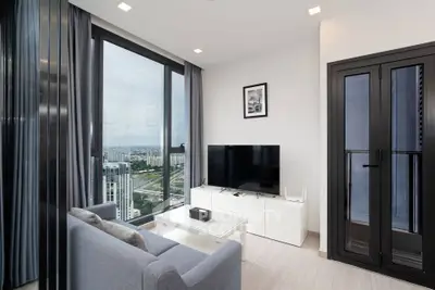 Modern living room with large windows offering stunning city views, sleek furniture, and a cozy ambiance.
