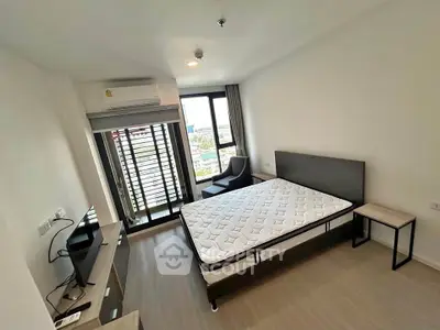 Modern bedroom with large window and minimalist furniture, offering a bright and airy atmosphere.