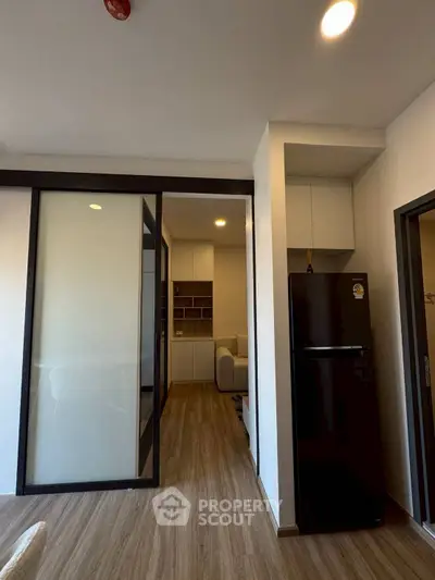 Modern apartment interior with sliding glass doors and sleek wooden flooring