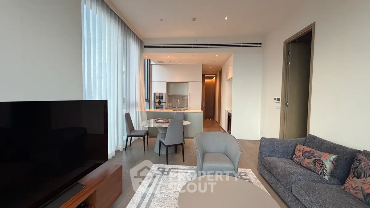 Luxurious modern living room with open kitchen and elegant furnishings in a high-end apartment.