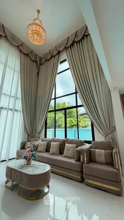 Luxurious living room with high ceilings, elegant drapes, and plush seating in a modern home.
