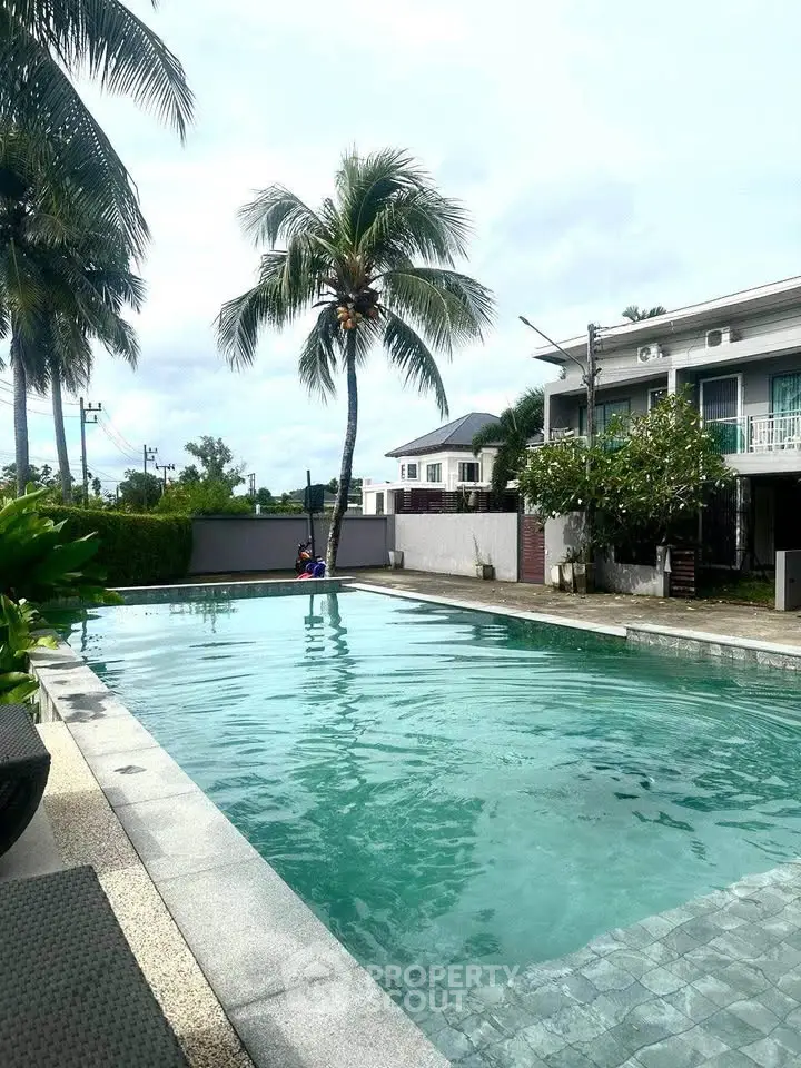Luxurious residential pool area with palm trees and modern architecture