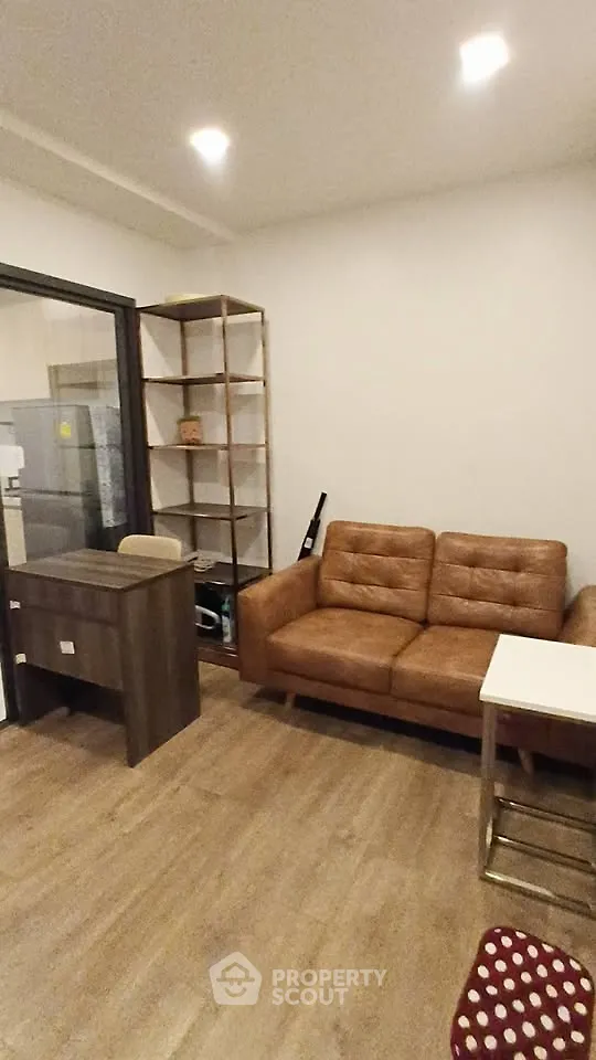 Modern living room with brown leather sofa and wooden furniture, ideal for cozy urban living.