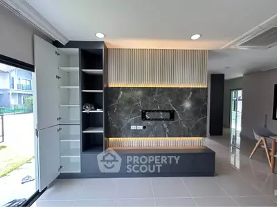 Modern living room with sleek built-in storage and elegant marble accent wall.