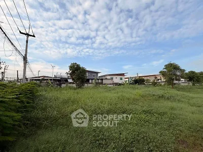 Expansive green land with potential for residential development under a clear blue sky.