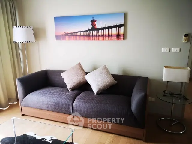 Stylish living room with modern sofa and coastal artwork, perfect for relaxation.