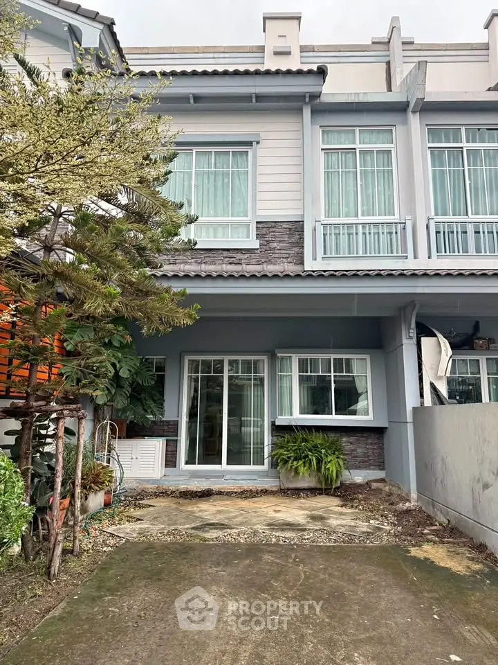 Charming townhouse exterior with modern design and lush greenery
