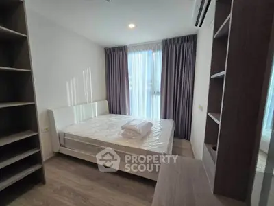 Modern bedroom with natural light, stylish shelving, and cozy ambiance in a contemporary apartment.