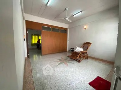 Spacious living room with unique flooring and wooden accents, perfect for relaxation and comfort.