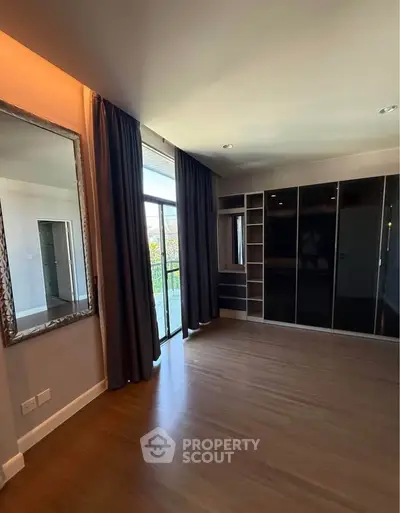 Spacious bedroom with floor-to-ceiling windows and sleek built-in wardrobe.