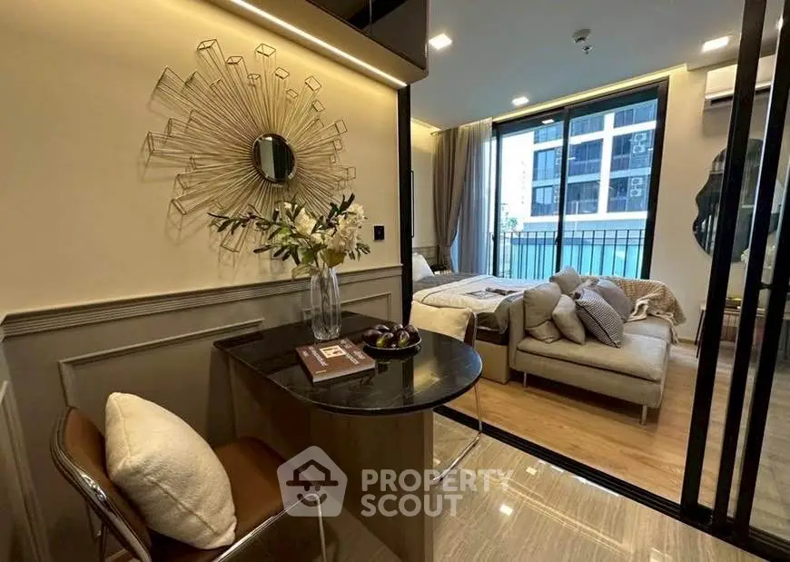 Modern studio apartment with stylish decor and large windows offering city views.