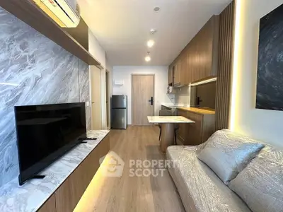 Modern living room with sleek design, featuring a TV, sofa, and stylish kitchen area.