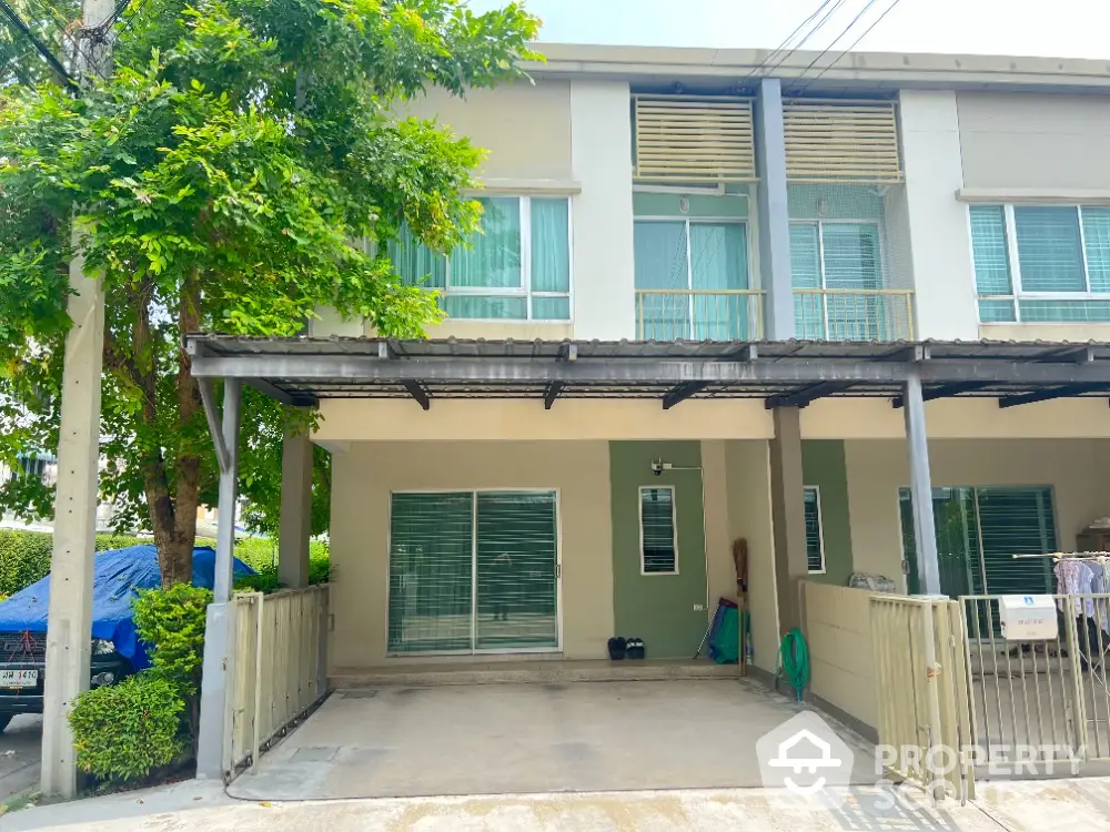 Modern townhouse with covered parking and lush greenery in a serene neighborhood.