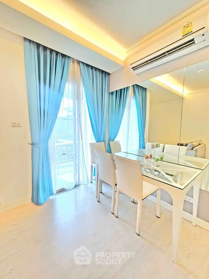 Bright dining area with elegant blue curtains and modern glass table