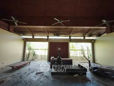 Spacious open-air room with ceiling fans and natural light, perfect for relaxation or gatherings.