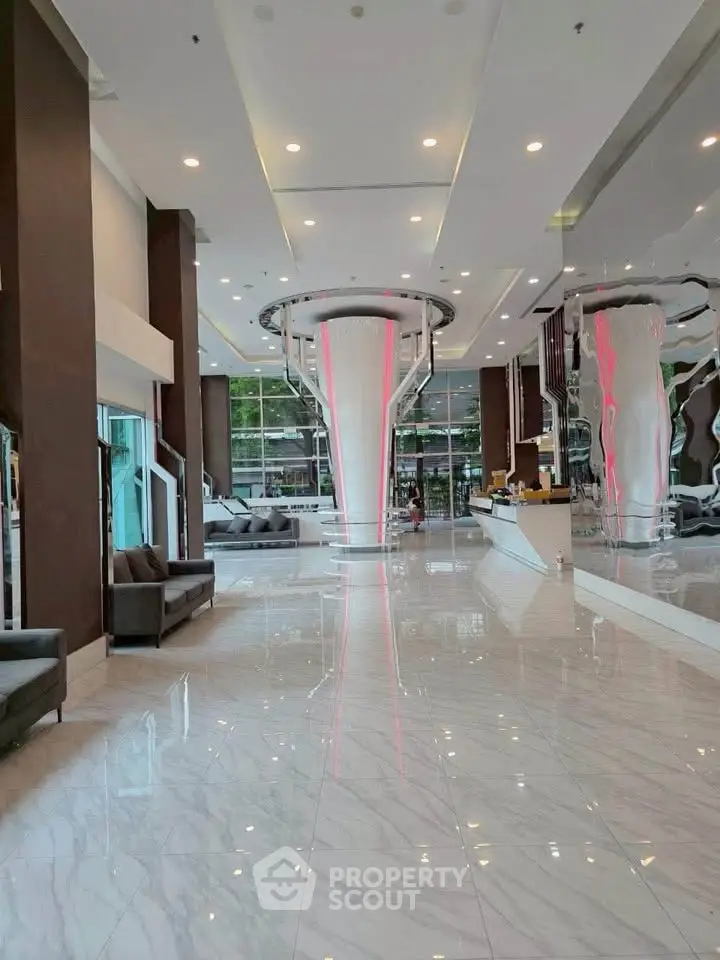 Luxurious modern building entrance with sleek design and glossy marble floors.