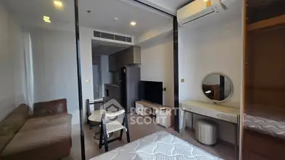 Modern studio apartment with open layout, featuring cozy living area and compact kitchen.