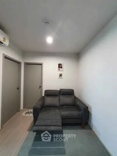Cozy living room with modern gray sofa and minimalist decor, perfect for relaxation.