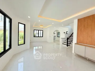Spacious modern living room with elegant staircase and large windows