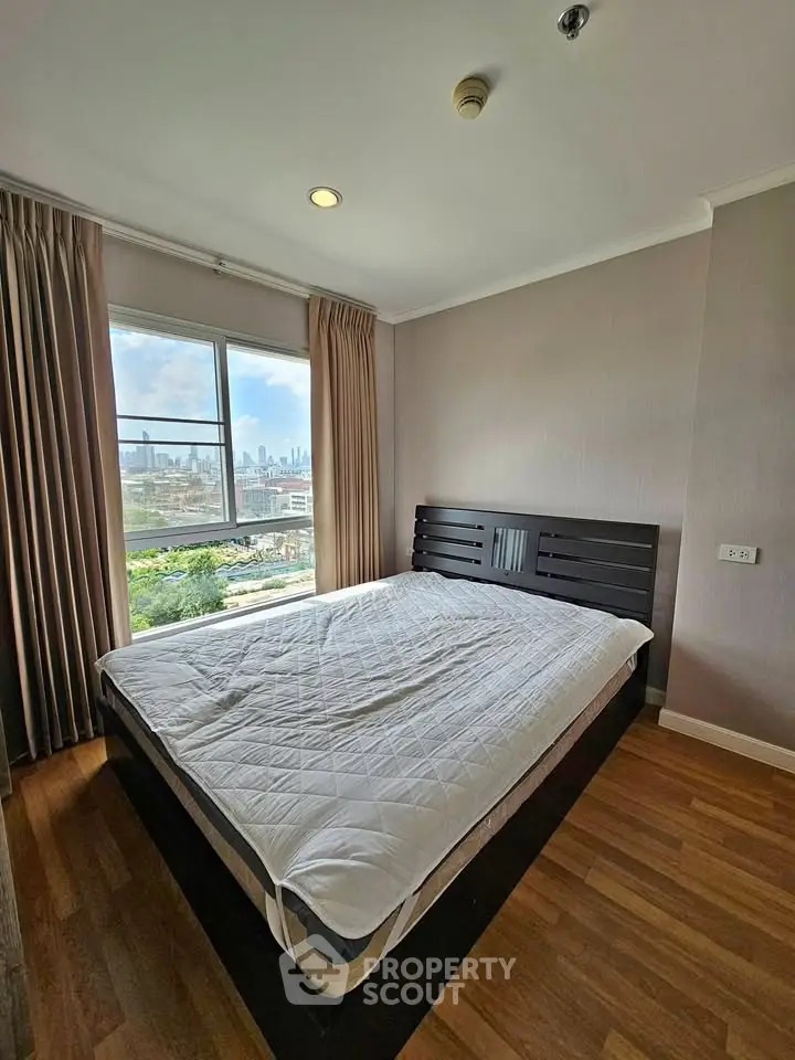 Spacious bedroom with city view and modern decor in high-rise apartment