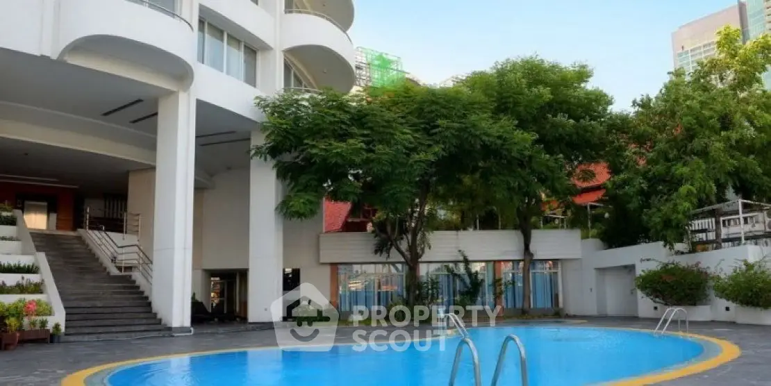 Luxurious apartment complex with inviting outdoor pool and lush greenery.