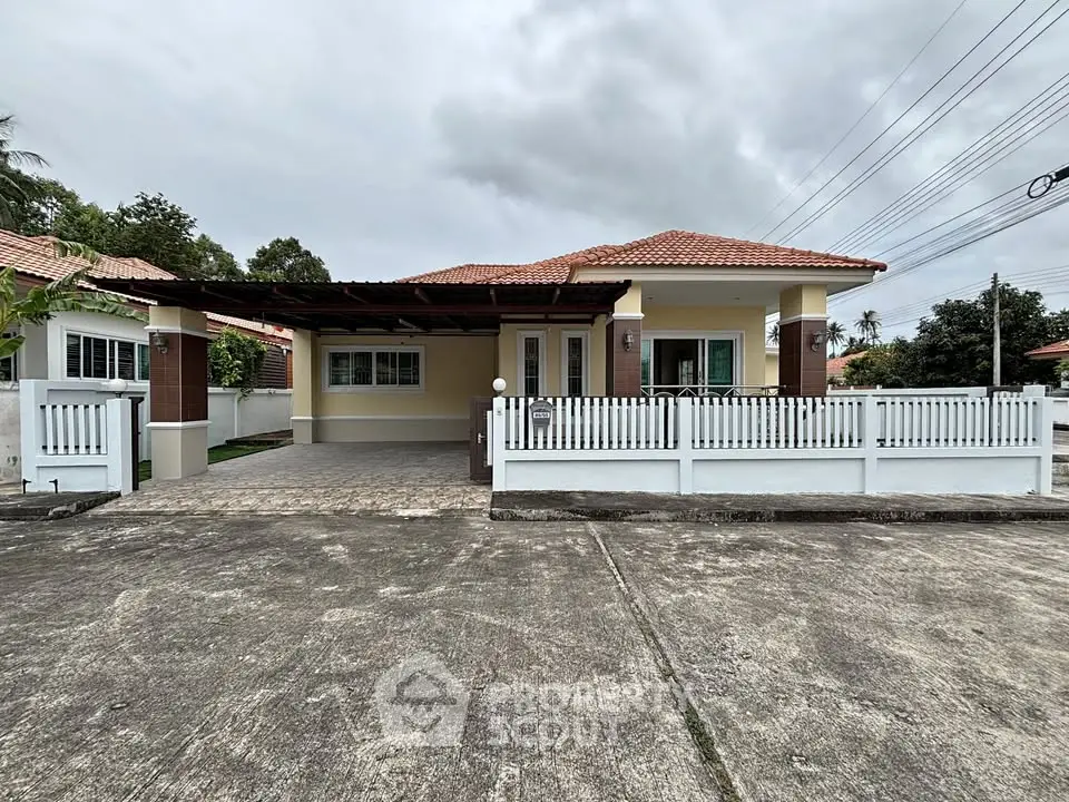 Charming single-story house with a spacious driveway and fenced yard, perfect for family living.