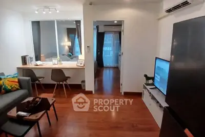 Modern living room with wooden flooring, stylish furniture, and a cozy ambiance.