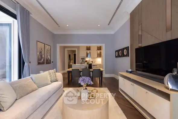 Elegant living room with modern decor and open layout leading to dining area.