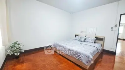 Spacious bedroom with wooden flooring and modern decor