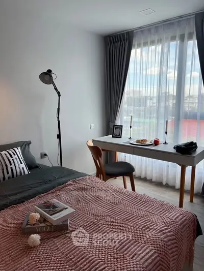 Cozy bedroom with stylish decor and large window offering natural light