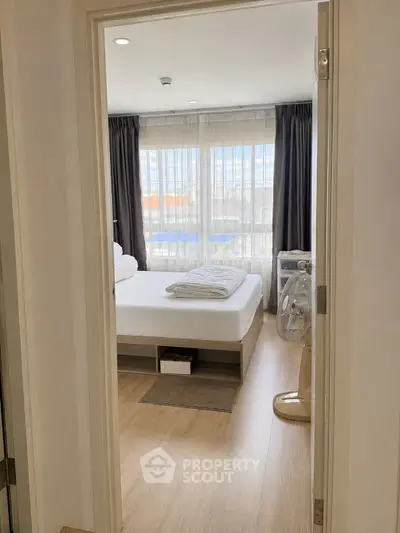 Cozy bedroom with large windows and modern decor, perfect for relaxation and comfort.