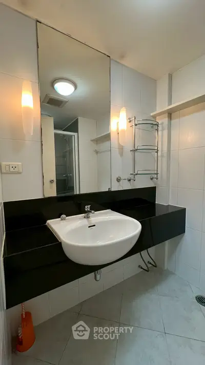 Modern bathroom with sleek black countertop and large mirror