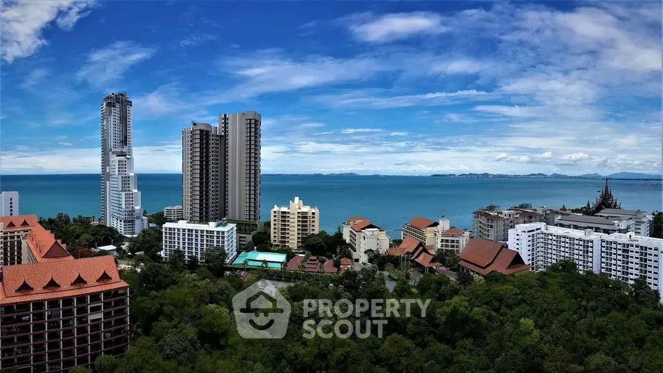 Stunning ocean view from high-rise buildings overlooking lush greenery and coastline.